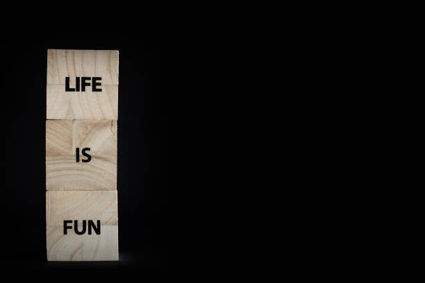 istock Three wooden cubes black background - Life is fun message 1306652843