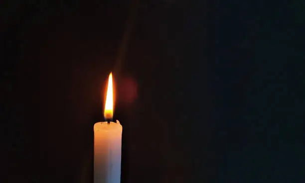 A candle flame burning in darkness