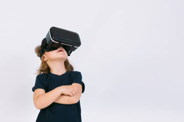istock Little girl with virtual reality glasses looking up on white background 1306654148