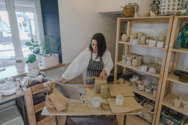 istock Female ceramist packing orders in her studio 1306660229