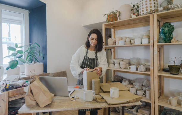 istock Female ceramist packing orders in her studio 1306660231