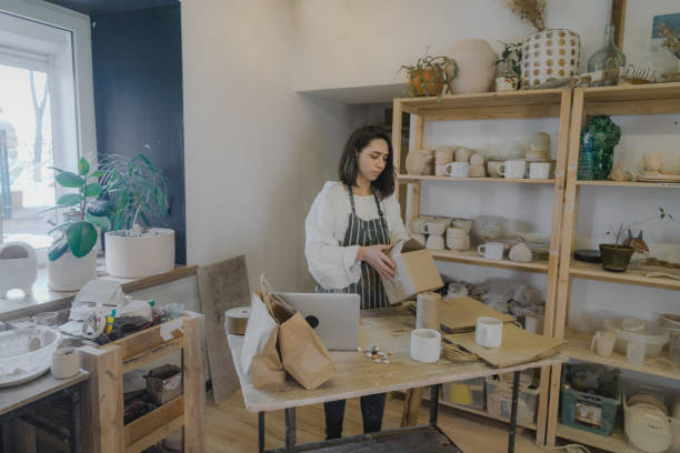 istock Female ceramist packing orders in her studio 1306660234