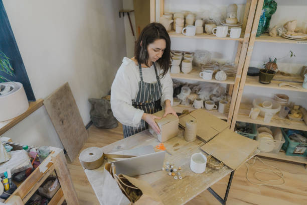 istock Female ceramist packing orders in her studio 1306660251