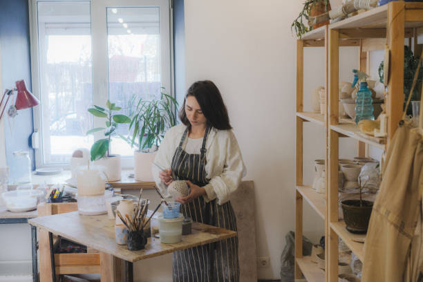 istock Female ceramist working in her studio 1306660262