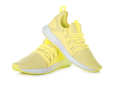 Pair of yellow sport shoes on white background.