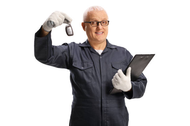 istock Auto mechanic holding a car key and a clipboard 1306663152