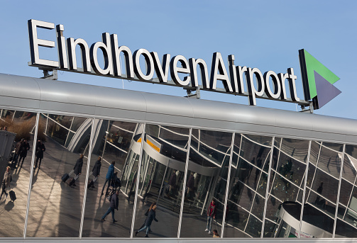 Eindhoven Airport, Eindhoven, North Brabant, Netherlands, december 30th 2015, passengersat the entrance of Eindhoven Airport, seen as a reflection in the glass of its facade - Eindhoven Airport is the second largest airport in the Netherlands and is owned by the \