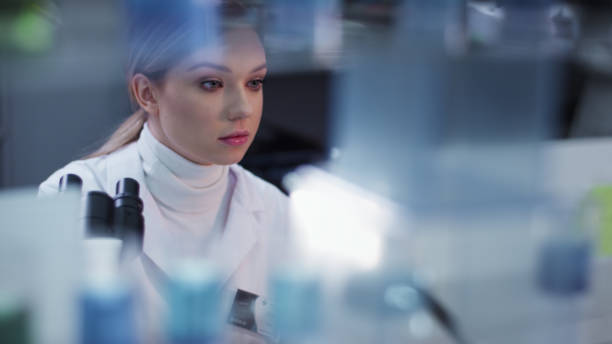 istock Female doctor working in laboratory. Studying medical samples. Looking through glassware and monitor 1306664679