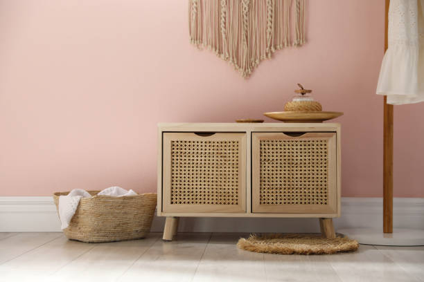 istock Wooden commode near pink wall in room. Interior design 1306665880