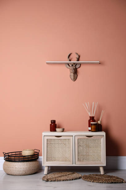 istock Wooden commode near coral wall in room. Interior design 1306666004