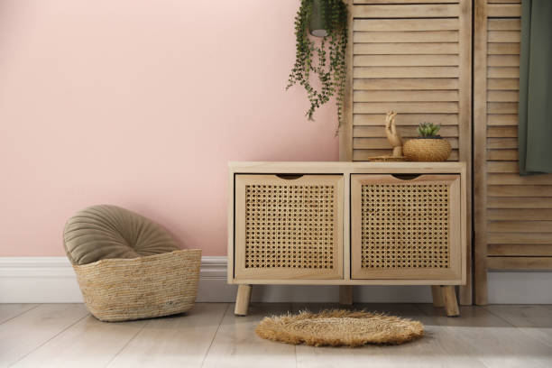 istock Wooden commode near pink wall in room. Interior design 1306666009