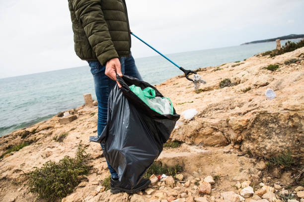 man collects garbage with a reach extender
