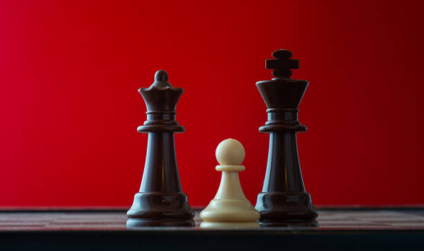istock small pawn on chess board against larger adversary concept of adversity ,discimination ,equality . 1306668163
