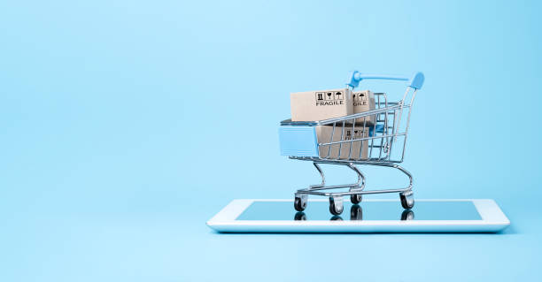 aislado de cajas de papel de envío dentro de carro de la compra azul en tableta con fondo azul y espacio de copia, compras en línea y concepto de comercio electrónico. - ecommerce fotografías e imágenes de stock