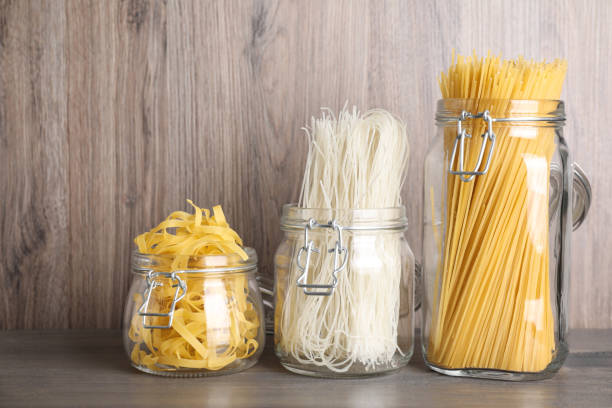 istock Different types of pasta in glass jars on wooden table 1306669232