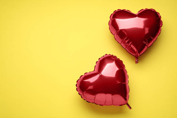 red heart shaped balloons on yellow background, flat lay with space for text. valentine's day celebration - heart balloon imagens e fotografias de stock