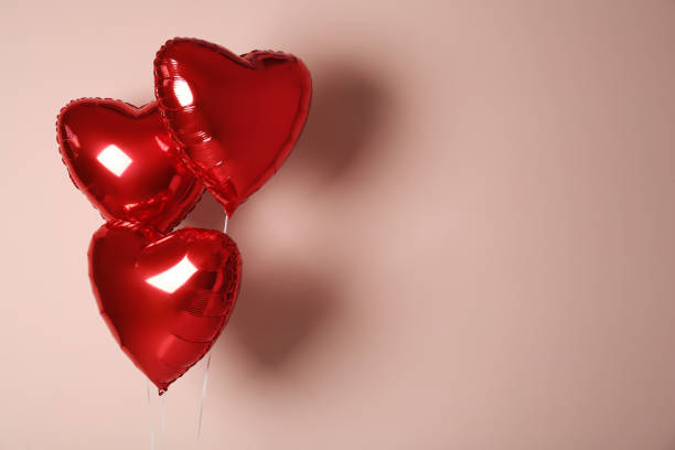 istock Red heart shaped balloons on pink background, space for text. Valentine's Day celebration 1306670219