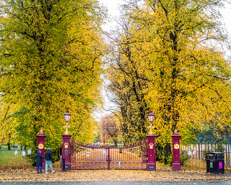 Glasgow, Scotland - People entering through the traditional Victorian gates to Victoria Park in Glasgow's West End.