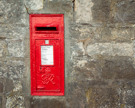 Antique Italian red mailbox, inserted in a white wall