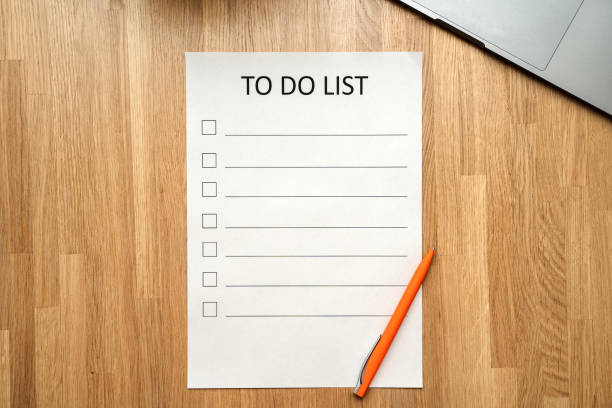 istock A man's hand holds a pen and writes a check list with checkboxes, a wooden table. Time management concept 1306670736
