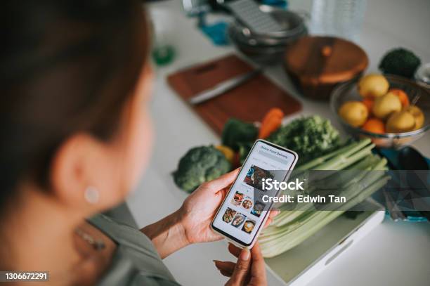 High Angle View Asian Chinese Womans Hand On Mobile App For Online Food Delivery In Front Of Kitchen Counter Stock Photo - Download Image Now