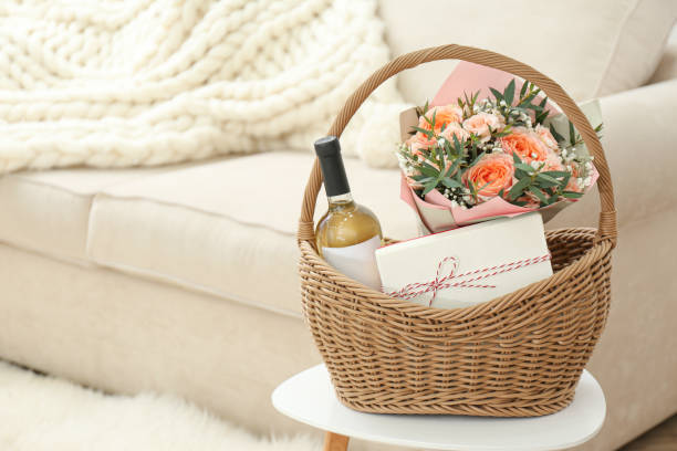 panier en osier avec des cadeaux sur la table à l’intérieur. espace pour le texte - wine bottle wine residential structure alcohol photos et images de collection