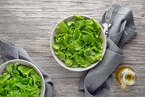 Healthy Green lettuce salad on wooden table background. Freshly picked of young green leaves