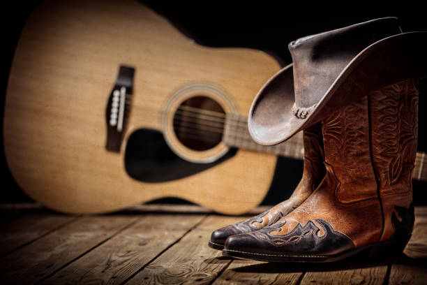 Country music festival live concert with acoustic guitar, cowboy hat and boots Country music festival live concert with acoustic guitar, cowboy hat and boots background cowboy photos stock pictures, royalty-free photos & images