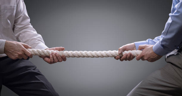 Business competition tug of war Two businessmen pulling tug of war with a rope concept for business competition, rivalry, challenge or dispute business battle stock pictures, royalty-free photos & images