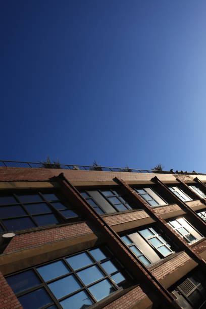 istock industrial building with blue sky reflected in windows 1306680779