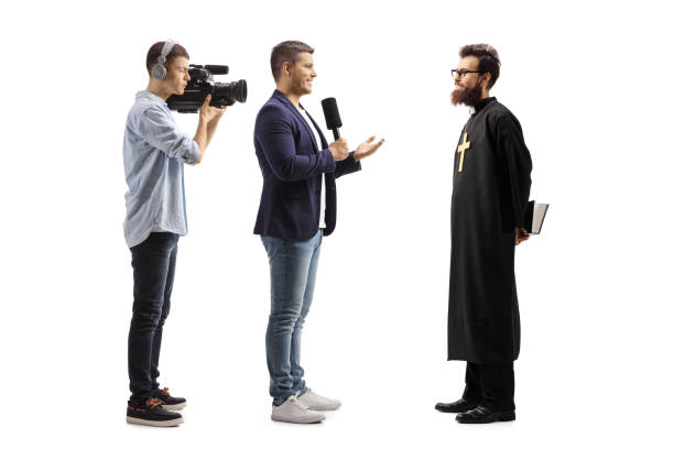 istock Reporter interviewing a catholic priest and a cameraman recording 1306682130