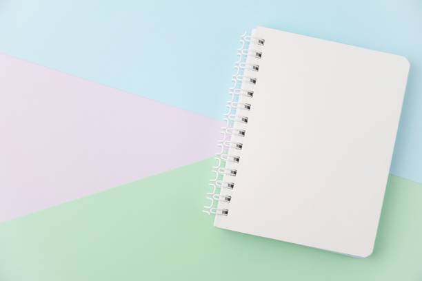 istock Top view of sketchbook on pastel background. Minimal work space. 1306683456