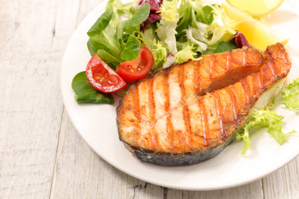 istock fried salmon steak and salad 1306684124