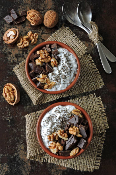 istock Two cups with yogurt with chia seeds, walnuts and dark chocolate. 1306687061