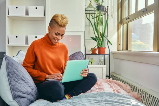 istock Happy Woman Using Laptop While Sitting On Sofa At Home 1306687243