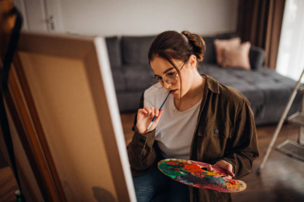 istock Girl painting on canvas 1306687508