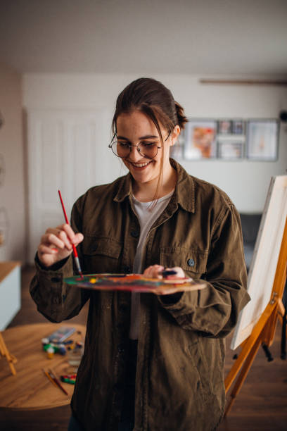istock Girl painting on canvas 1306688255