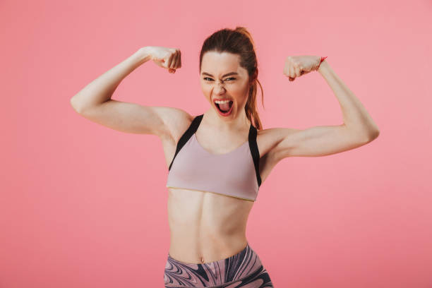 istock Cheerful sportswoman posing in studio while showing her biceps 1306689403