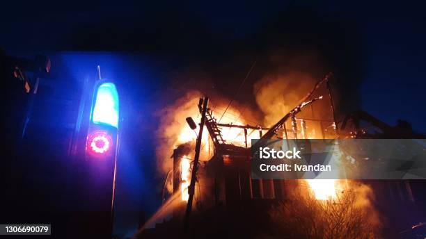 The Roof Of The House Is On Fire The Residential Building Burn Village Firefighters Put Out A Fire Fire Truck Headlights And Panel Siren Signal Stock Photo - Download Image Now
