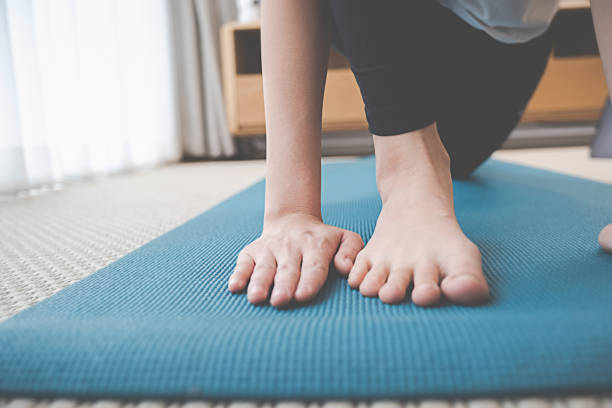 istock Training at Home. Sporty woman doing yoga plank while watching online tutorial on laptop exercising in living room. 1306690735