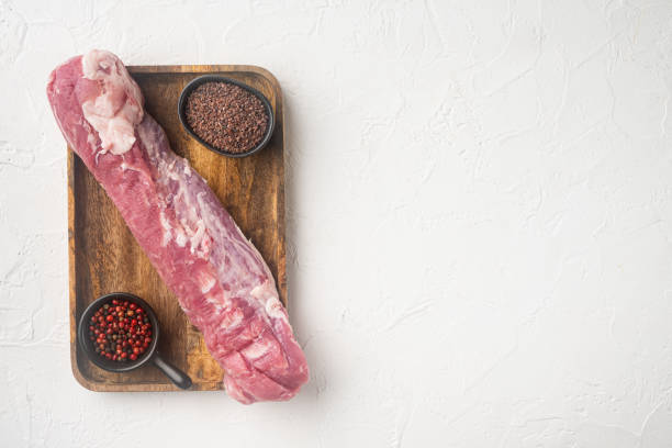 lomo de cerdo orgánico crudo, en bandeja de madera, sobre fondo de piedra blanca, vista superior plana, con espacio de copia y espacio para el texto - fillet meat portion fillet steak fotografías e imágenes de stock