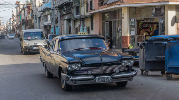 Authentic view and atmosphere on the streets of Havana. Havana, Cuba-December 2017: Authentic view and atmosphere on the streets of Havana. Cuban car driving true the neighbourhood filled up with local people and colonial residences in the background. driveway colonial style house residential structure stock pictures, royalty-free photos & images