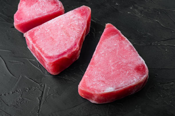 istock Frozen tuna fish steaks, on black stone background 1306694081
