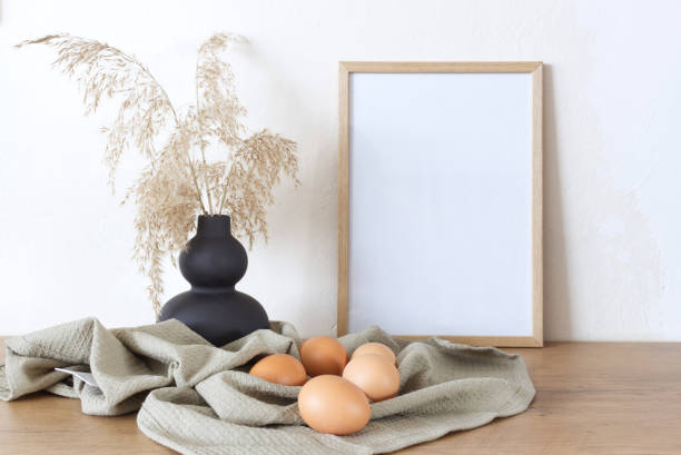istock Spring, Easter still life. Empty picture frame mockups. Linen tablecloth, hen eggs. Reed grasses in a ceramic jug. Farmhouse, Scandinavian interior. 1306695329