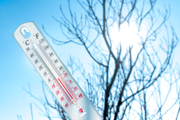 le thermomètre se trouve sur la neige et montre une température négative par temps froid sur le ciel bleu. conditions météorologiques avec un air bas et des températures ambiantes. changement climatique et réchauffement climatique - frozen ice sky sun photos et images de collection