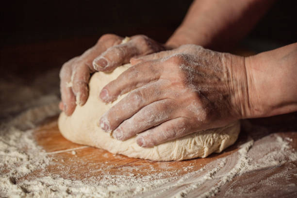 istock Senior woman hands knead dough 1306695779