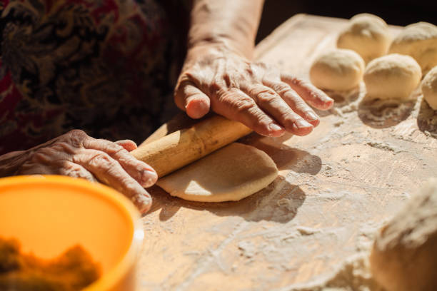 istock Senior woman hands rolling out dough 1306695825