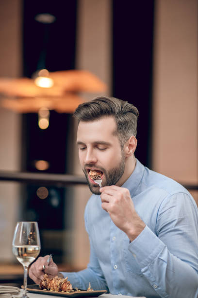 istock Bearded man eating seafood at the restaurant and looking involved 1306700066