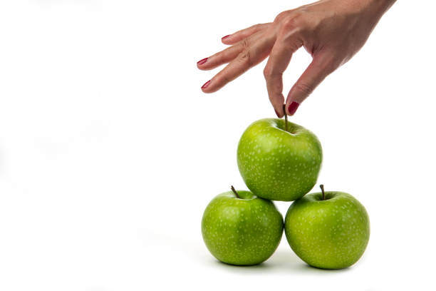 istock Woman hand holding green apples on white background 1306704280