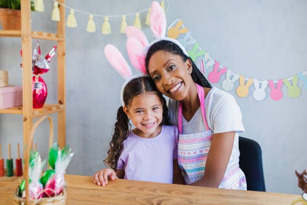 istock Mother and daughter looking at camera - celebrating Easter at home 1306705524
